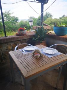 a wooden table and chairs on a patio at Locanda Miranda in Tellaro