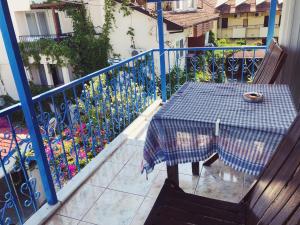 a table on a balcony with a blue fence and flowers at Dove Apart Hotel in Fethiye