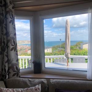 uma janela com vista para uma prancha de surf numa varanda em 225 Buttercup Swanage Bay View - Vacation Home em Swanage