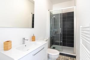 a white bathroom with a sink and a shower at Fontaines de Valence d'Agen Centre Ville Netflix Proche Parking Gratuit in Valence-dʼAgen