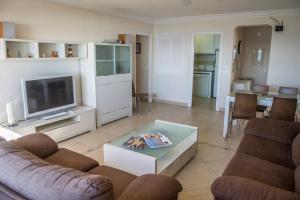 a living room with a couch and a tv at Hamilton Court in Santo Tomás