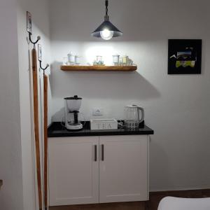 a kitchen with white cabinets and a black counter top at Casa Lela II in Fuencaliente de la Palma