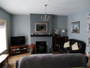 a living room with a couch and a fireplace at Necarne Manor Apartment in Irvinestown