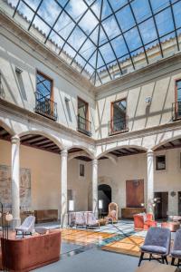 un vestíbulo vacío con sillas y techo de cristal en NH Collection Salamanca Palacio de Castellanos, en Salamanca