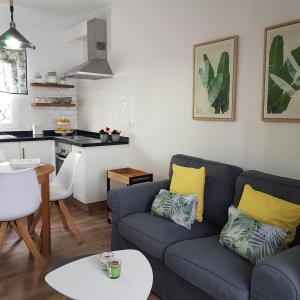 uma sala de estar com um sofá azul e uma cozinha em Casa Lela II em Fuencaliente de la Palma