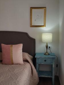 a bedroom with a bed and a table with a lamp at Casa Lela II in Fuencaliente de la Palma