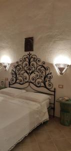 um quarto com uma cama com uma cabeceira de metal em Cantina Perandria em Monti