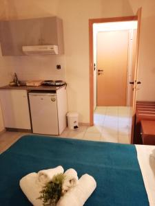 um quarto com uma cozinha com toalhas numa cama em Hotel Eleni em Paralia Dionysiou