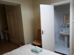 a small bathroom with a bed and a sink at Lavelle's Seaside House & Mickey's Bar in Achill Sound