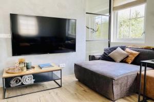 a living room with a couch and a large flat screen tv at Duinvilla Sela in Hollum