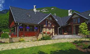 a house with a green hill in the background at Pivovar BUC Kvačany in Kvačany