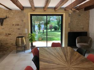 een woonkamer met een houten tafel en stoelen bij Gite le domaine Aubazen in La Chapelle-Aubareil