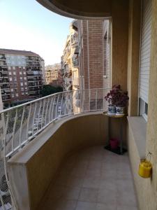 einen Balkon mit einem Geländer und einem Tisch mit Blumen in der Unterkunft Apartamento la luna in Castellón de la Plana
