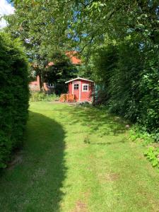 un giardino con un capanno rosso sullo sfondo di Ferienwohnung Wentorf Amt Sandesneben a Wentorf