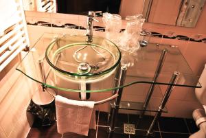 a glass sink in a bathroom with a towel at Hotel Magic GT Trivale in Piteşti