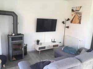 a living room with a couch and a fireplace at Ferienhaus - Heimathafen Tossens in Butjadingen