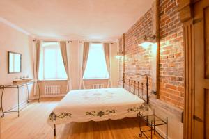 a bedroom with a bed and a brick wall at Apartament Rustical in Wrocław
