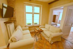a living room with two white couches and a television at Apartament Rustical in Wrocław +8 photos