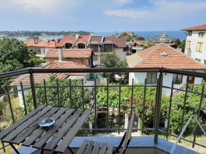 a balcony with a wooden bench and a view of buildings at La MER 2 in Tsarevo