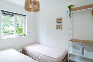 オッテルローにあるVakantiehuisje Spechtのベッドが2つと窓のある部屋