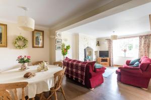 a living room with a table and a red couch at 2 Tan Yr Eglwys in Pontardawe