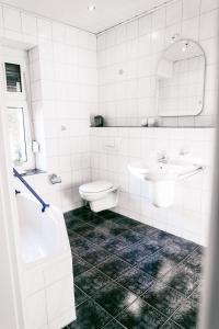 a white bathroom with a toilet and a sink at Klärchen's Stube in Telgte