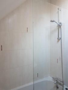 a white bathroom with a shower and a tub at Binfield Annexe in Bracknell