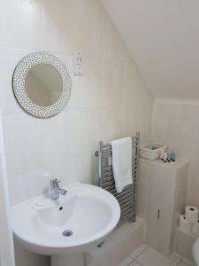 a white bathroom with a sink and a mirror at Binfield Annexe in Bracknell