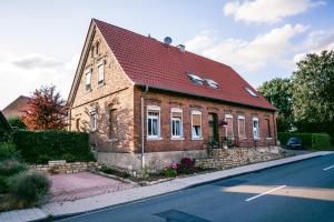 a brick house with a red roof on a street at Klärchen's Stube in Telgte