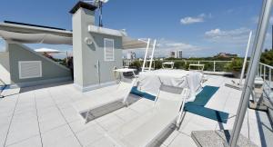 a balcony with a table and chairs on a roof at Hotel Meublè Nazionale in Lignano Sabbiadoro