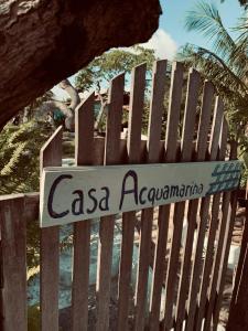 ein Schild an einem Holzzaun am Strand in der Unterkunft Casa Acquamarina in Atins