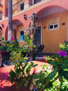 einen Brunnen im Innenhof eines Gebäudes mit Blumen in der Unterkunft Hotel Angra in Loreto