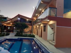 a house with a swimming pool next to a house at Pousada Málaga in Porto De Galinhas +29 photos