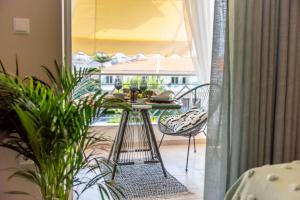 a table and chairs in a room with a window at Cozy and Style in Preveza