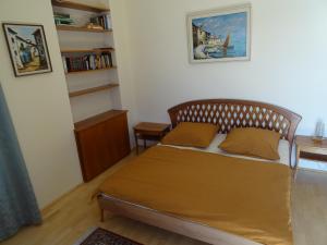 1 dormitorio con cama y estante para libros en Fantastic Lake and Mountain View, First Row Lakeside en Gmunden