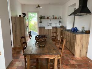 cocina con mesa de madera y algunas sillas en Aou Saintou, en Morlaas