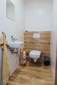 a bathroom with a white toilet and a sink at Apartmány Paľovci in Zuberec