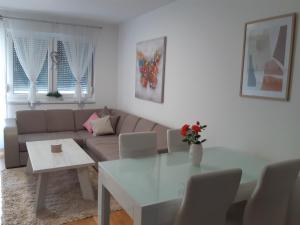 een woonkamer met een bank en een tafel bij Elena apartmani in Tuzla