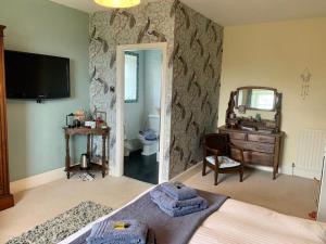 a bedroom with a bed and a mirror and a dresser at Low Gingerfield Farm B&B in Richmond