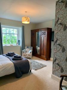 a bedroom with a bed and a chair and a window at Low Gingerfield Farm B&B in Richmond