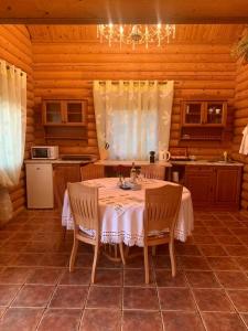 ein Esszimmer mit einem Tisch und Stühlen in einer Küche in der Unterkunft Фінський будинок для ідеального романтичного чи сімейного відпочинку in Makovishche