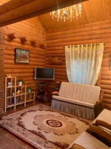 een woonkamer van een blokhut met een kroonluchter bij Фінський будинок для ідеального романтичного чи сімейного відпочинку in Makovishche
