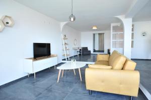 een woonkamer met een bank, een tv en een tafel bij Sunset Apartment Lagadin in Ohrid
