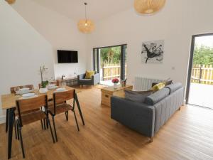 a living room with a couch and a table at Lunnon Barn in Droitwich