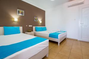 two beds in a room with blue and white at Green Velvet Thassos in Pefkari