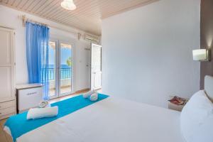 a bedroom with a large bed and a large window at Green Velvet Thassos in Pefkari