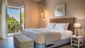 a bedroom with a large bed and a balcony at Beachfront Suites Lourdas in Lourdata
