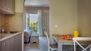 a kitchen with a table and a dining room at Beachfront Suites Lourdas in Lourdata