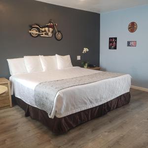 a bedroom with a bed with a motorcycle on the wall at Deluxe Inn in Seligman