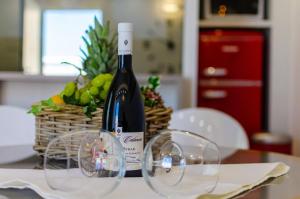 una bottiglia di vino e bicchieri su un tavolo di Calanica Boutique Apartments a Cefalù